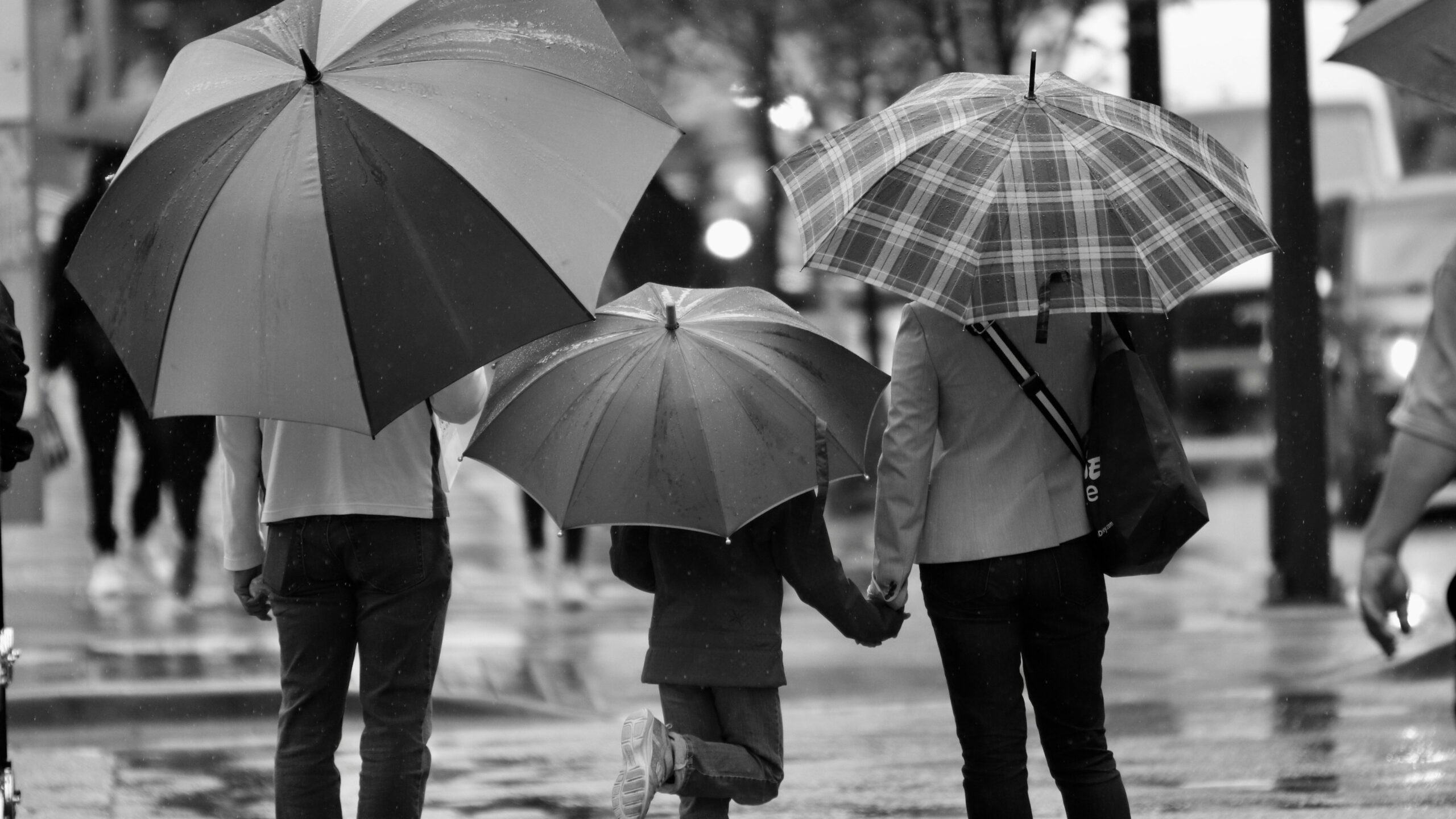 child walking with parents holding hands 