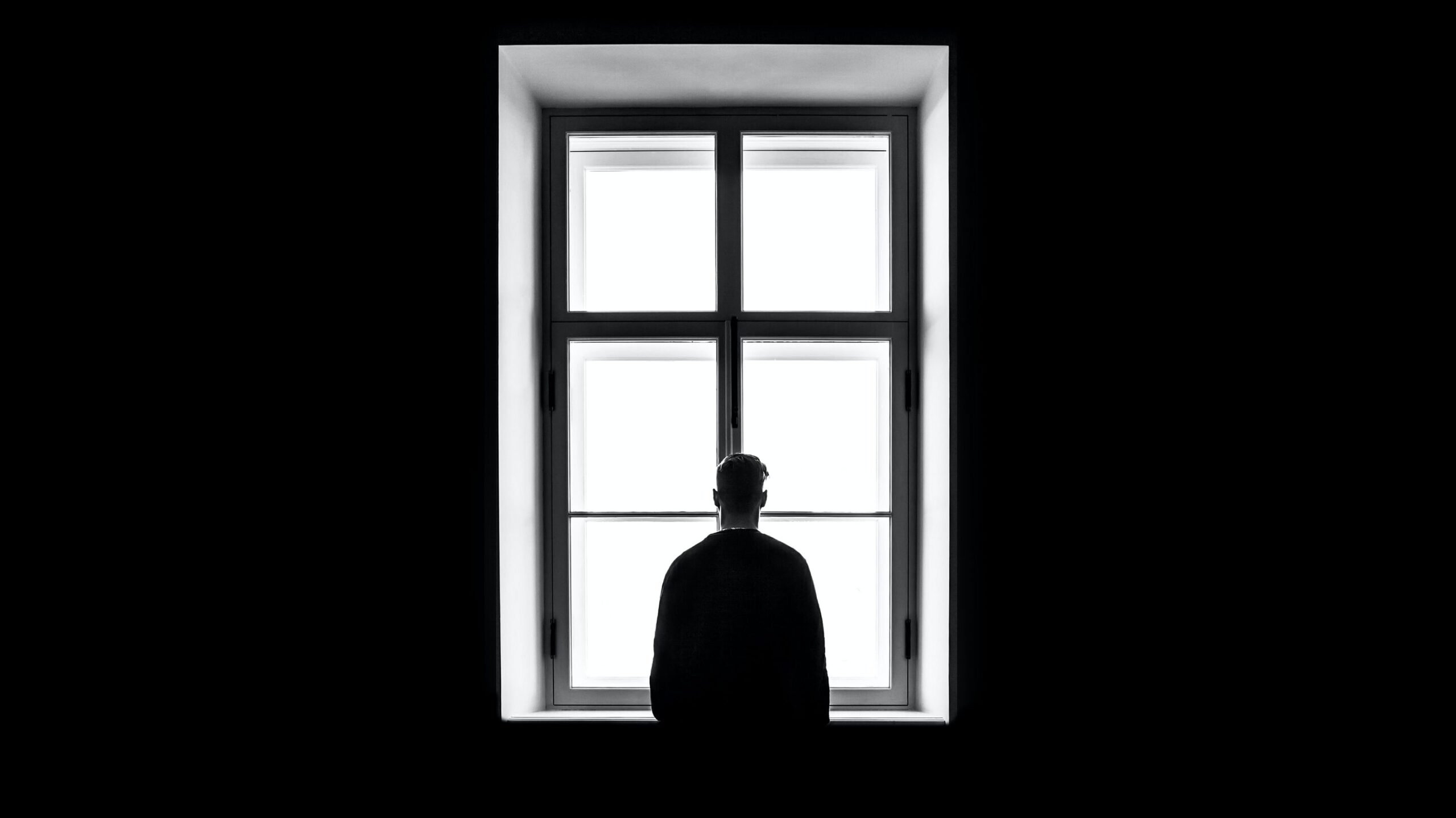 man standing alone at a window. how to build trust when you have trust issues
